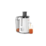 A white Moulinex juicer in operation, shown dispensing fresh orange juice into a glass, with visible fruit pulp collected in the transparent rear container.